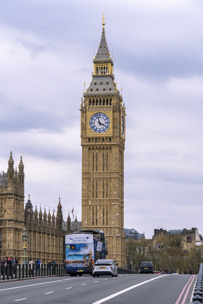 Big Ben towering over London street scene with vehicles and pedestrians.